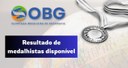Para cego ver: imagem com plano de fundo mostrando recorte de um mapa em formato de globo. Logo da OBG na parte de cima, ao lado de uma medalha em preto e branco e os dizeres abaixo: Resultado de medalhistas disponível